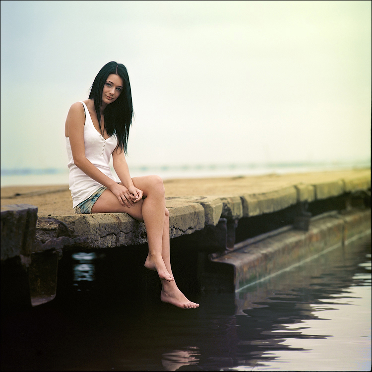 фото про девушку, которая сидит на пирсе. и все.