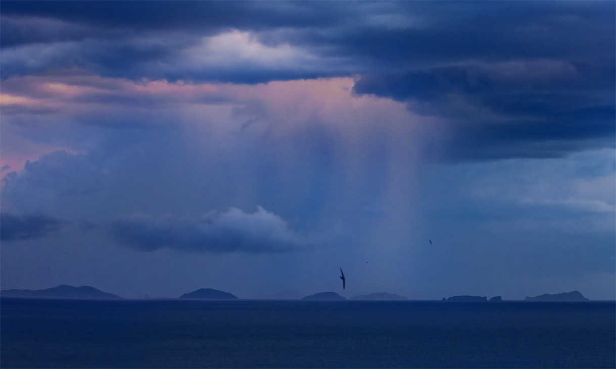 Закат дождем спустился в море Пробив завесу облаков
